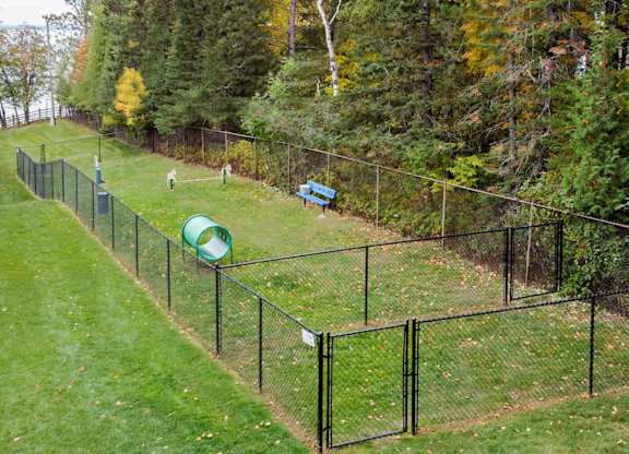 A black fence surrounds a green playground.