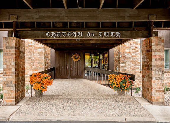 The entrance to Chateau Du Luth is framed by two large flower pots.