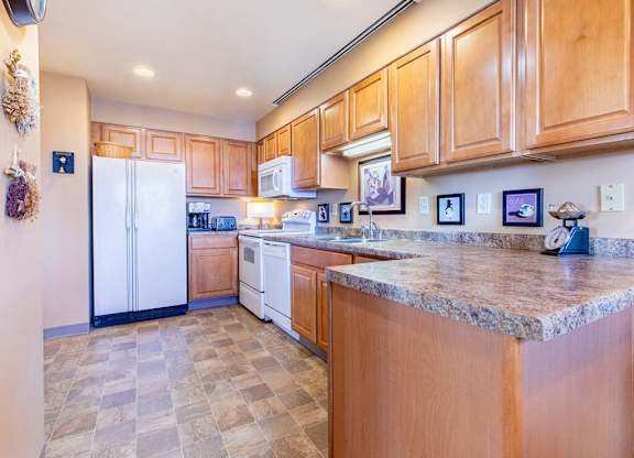 A kitchen with wooden cabinets and a marble countertop.