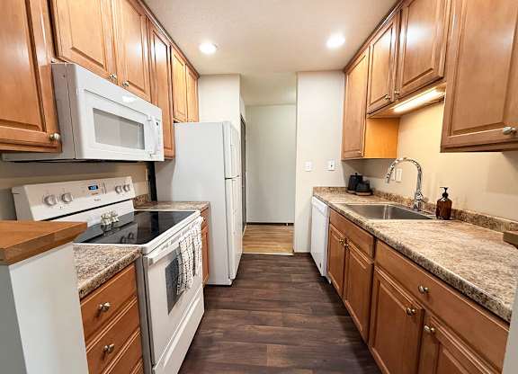 A kitchen with wooden cabinets and a granite countertop.