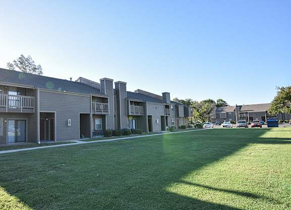 Apartment complex with a green lawn in front.