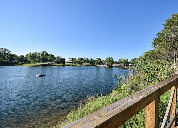 A serene lake with a boat and a forested shore.
