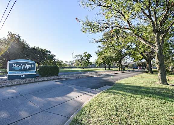 A sign for MacArthur's Lake is visible on the side of a road.