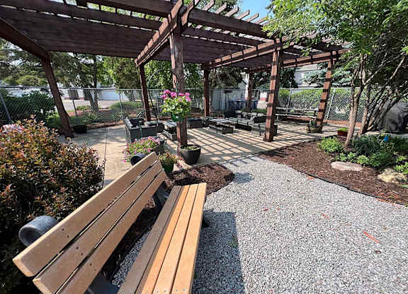 a park with a wooden bench and a pergola
