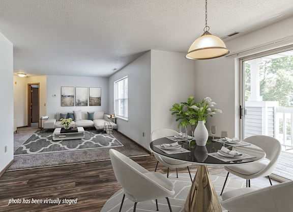 A modern living room with a glass table and white chairs.