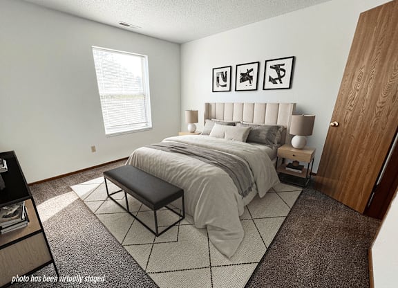 A bedroom with a large bed and a bench in front of it.