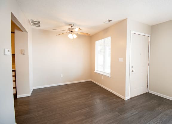 A room with a ceiling fan and a window.