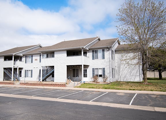 Apartment building with a parking lot in front.