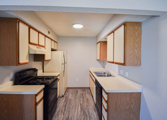 Kitchen with white cabinets, refrigerator, oven, and dishwasher