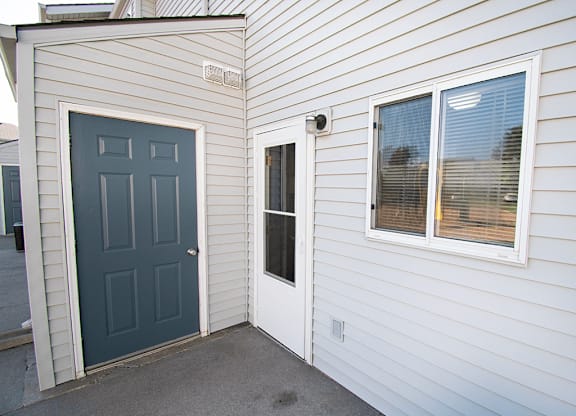 A white house with a blue door and window.