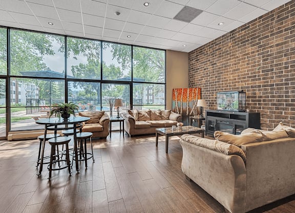 a living room with couches and a table in front of a wall of windows