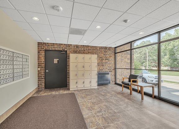 a lockers room with a desk and a chair in a building with large windows