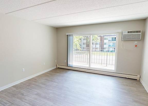 A room with a sliding glass door leading to a balcony.