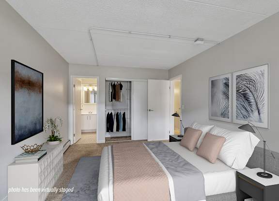 A bedroom with a large bed, a wardrobe, and a painting on the wall.