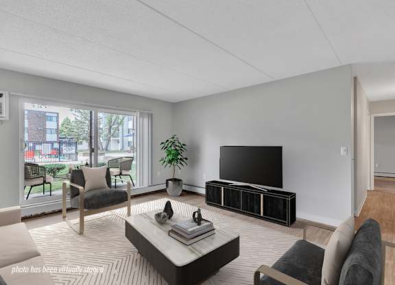 A living room with a flat screen TV and a large window.