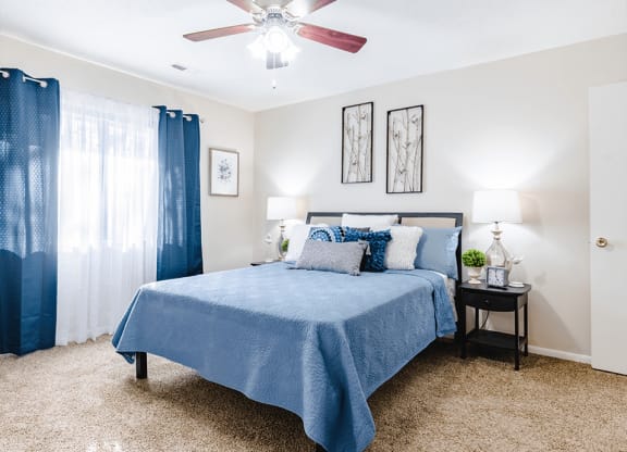 a bedroom with a bed and a ceiling fan