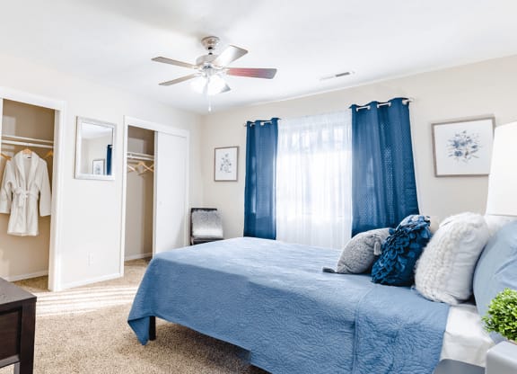 a bedroom with a bed and a ceiling fan