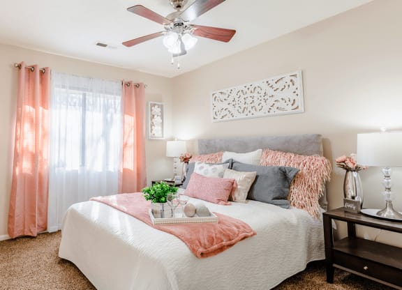 a bedroom with a large bed and a ceiling fan