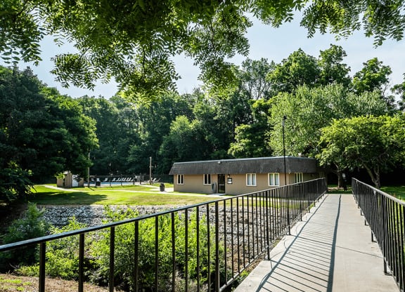 a bridge crosses a pond in front of a building
