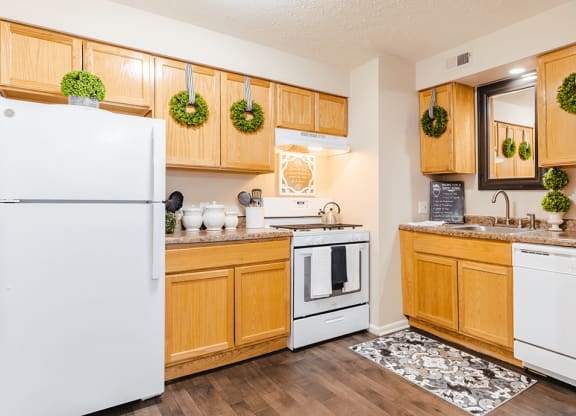 a kitchen with white appliances and wooden cabinets