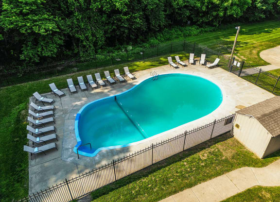 an aerial view of a resort style pool with lounge chairs and a hot tub
