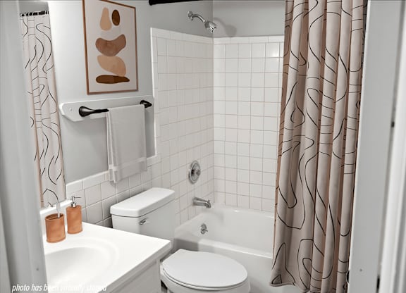 A white toilet sits next to a white sink in a bathroom.
