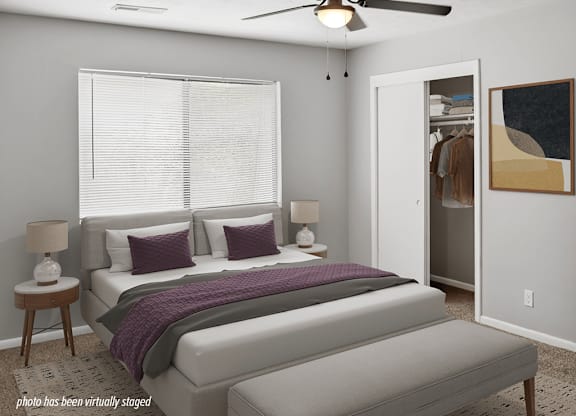 A bedroom with a bed, nightstands, and a ceiling fan.