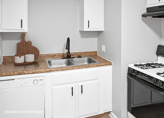 A kitchen with white cabinets and a black stove top.