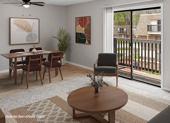 A dining room with a table set for four and a view of a balcony.