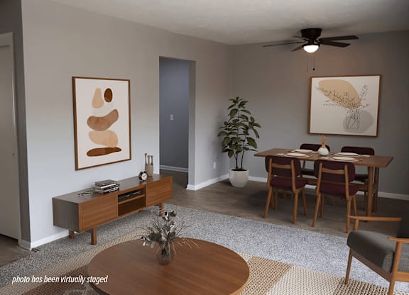 A living room with a brown coffee table and a grey rug.