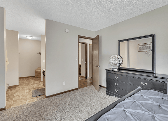 a bedroom with a dresser and mirror