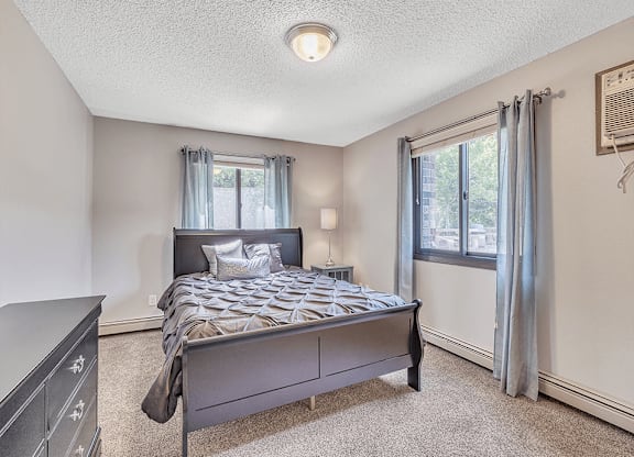 a bedroom with a bed and two windows