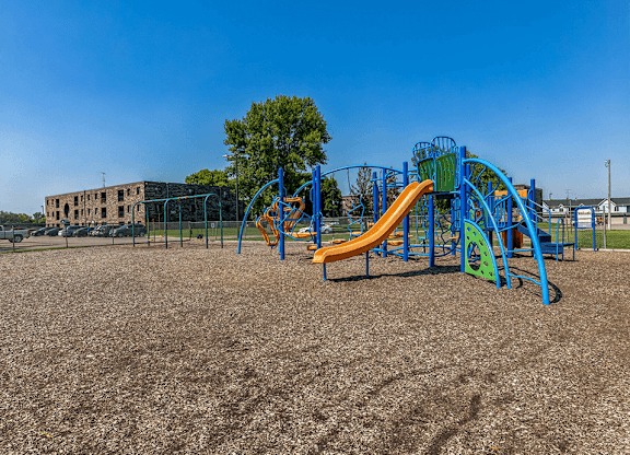 a playground with a yellow and blue slide and a green and blue climbing structure