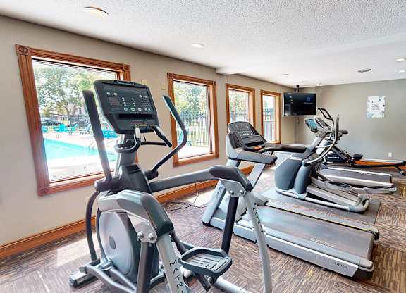 A gym with treadmills and elliptical machines.