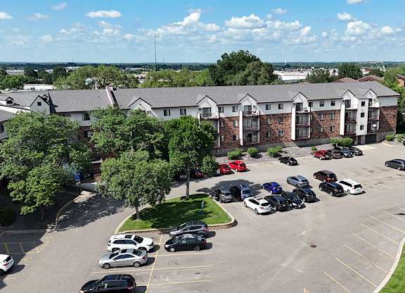 A parking lot with cars and a building in the background.