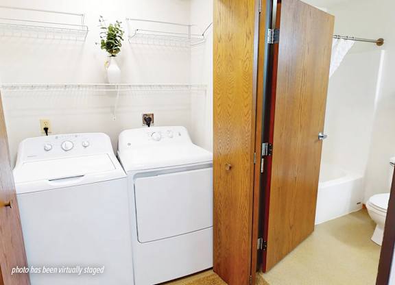 A photo has been virtually staged with two washing machines in a laundry room.