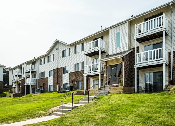 a photo of a row of apartment buildings on a grassy hill