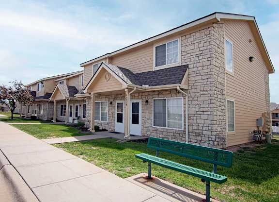 A row of houses with a green bench in front of them.