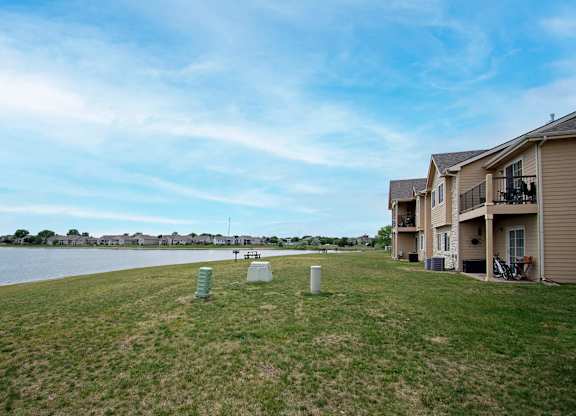 A grassy area with a few objects and apartment buildings in the background.