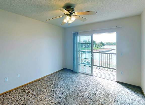 A room with a ceiling fan and a carpeted floor.