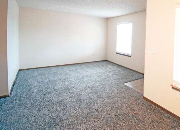 A room with a carpeted floor and a window.
