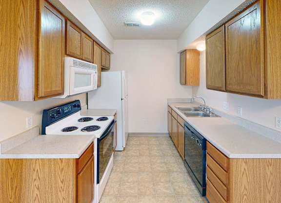 A kitchen with wooden cabinets and a white fridge.
