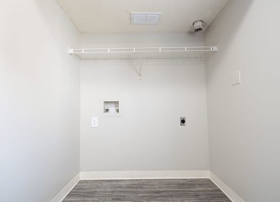 A room with a white wall and a grey floor.