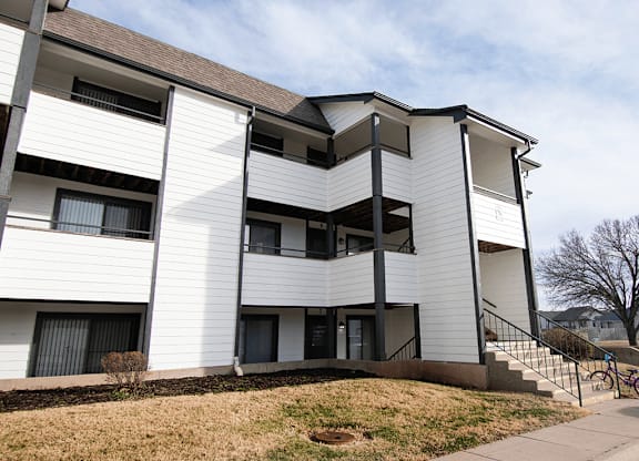 Apartment building with a white facade and black railings.