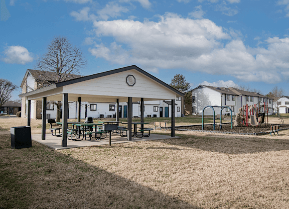 A park with a pavilion, picnic tables, and playground equipment.