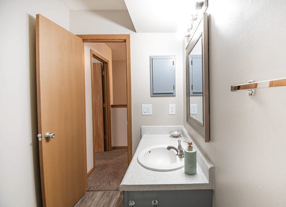 A bathroom with a sink, mirror, and medicine cabinet.