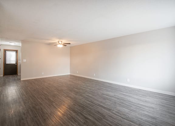 A room with a wooden floor and a ceiling fan.