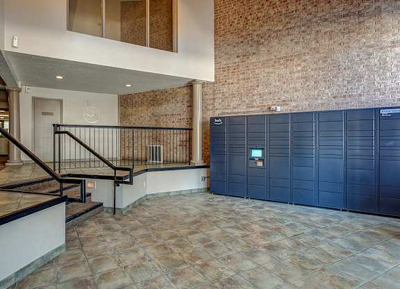 A room with a brick wall and a staircase with a metal railing.