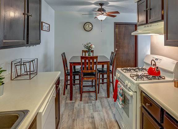 A kitchen with a table and chairs in the middle.