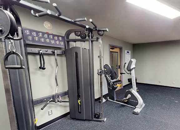 A gym with a weight machine and a treadmill.
